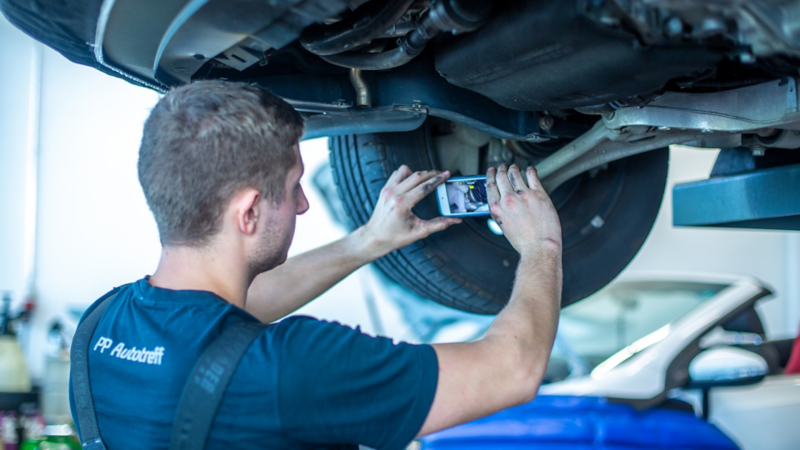 Ein Service Mitarbeiter begutachtet ein Fahrzeug mit der Volkswagen Service Cam