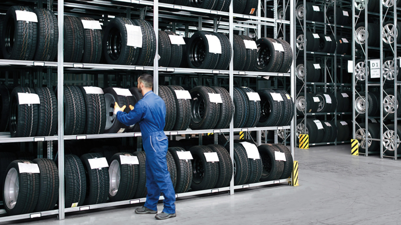 VW technician taking tyre off shelf