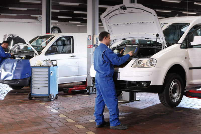 Volkswagen van specialist using diagnostic equipment under hood of van