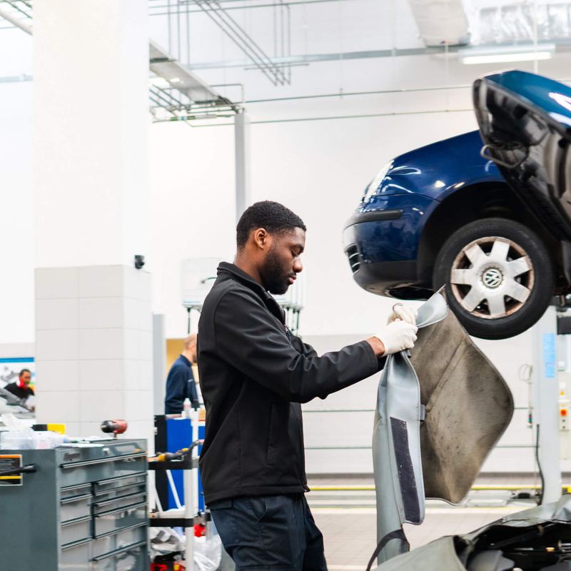 a mechanic working on a Volkswagen car in the garage