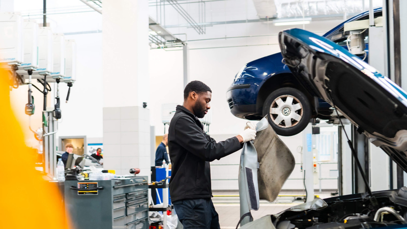 a mechanic working on a Volkswagen car in the garage