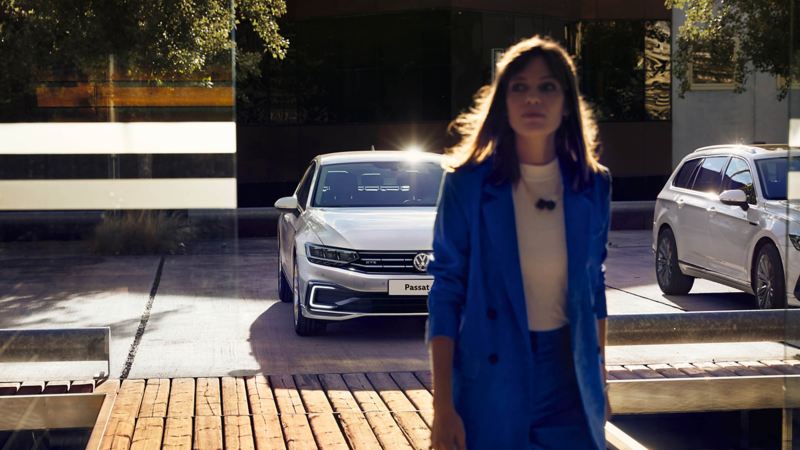 A woman in front of Passat GTE car