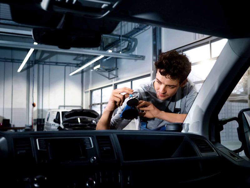 a VW maintenance expert looking at the windscreen of a vehicle