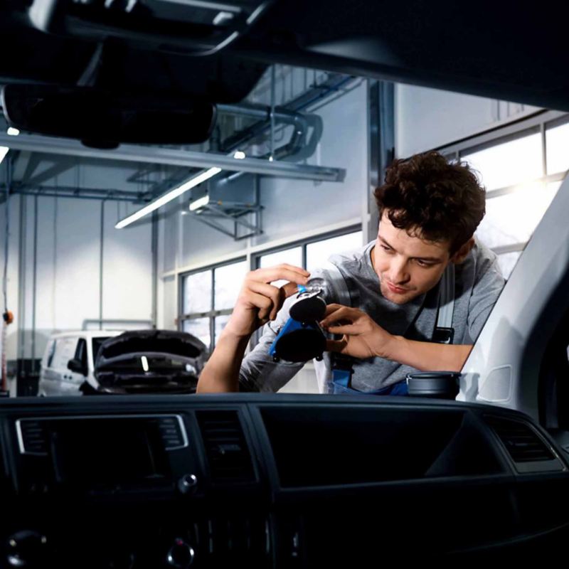 a man looking at a VW van windscreen