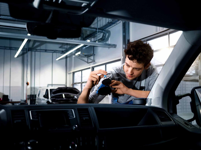 a man looking at a VW van windscreen