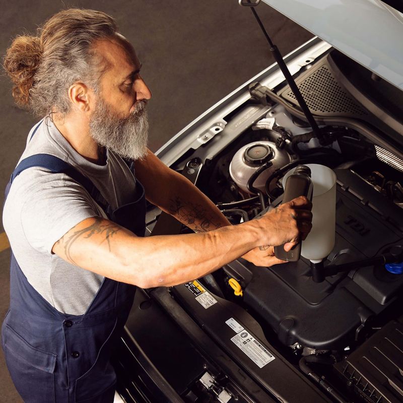 A Volkswagen service employee using the right engine oil for a Volkswagen vehicle