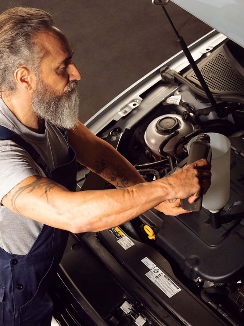 A Volkswagen service employee using the right engine oil for a Volkswagen vehicle