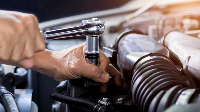 Técnico de Volkswagen pone bujía en un motor de auto. 
