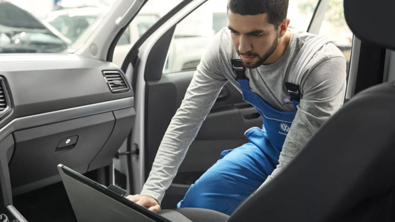 Hombre dando mantenimiento a su nuevo auto adquirido con los créditos automotrices de Volkswagen