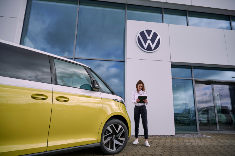 Mujer del servicio técnico para eléctricos de VW al lado del ID. Buzz.