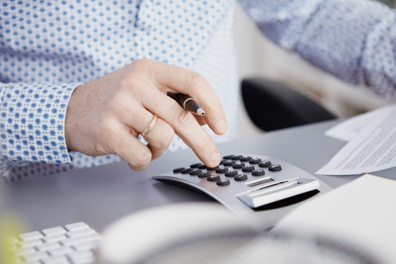 Dealer in VW van centre with calculator on desk