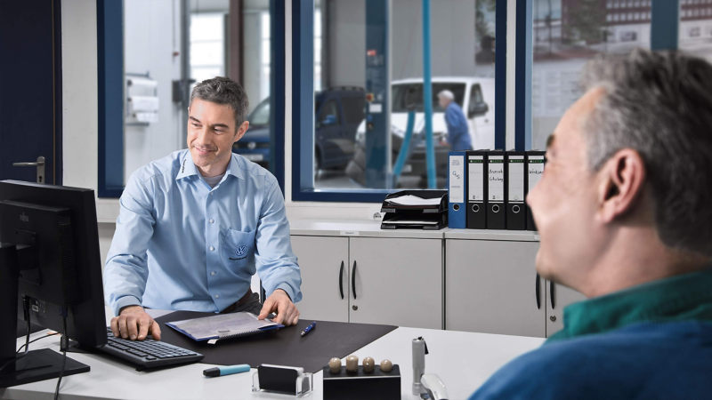 VW dealer and customer purchasing a car