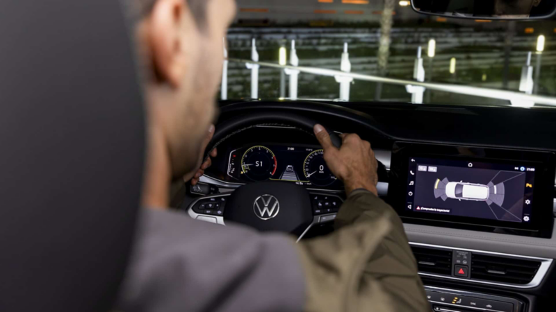Conductor observa en la pantalla de Taos 2025 la acción de los sensores de estacionamiento. 