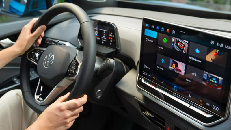 The screen of a VW, with the driver using the Voice assistant