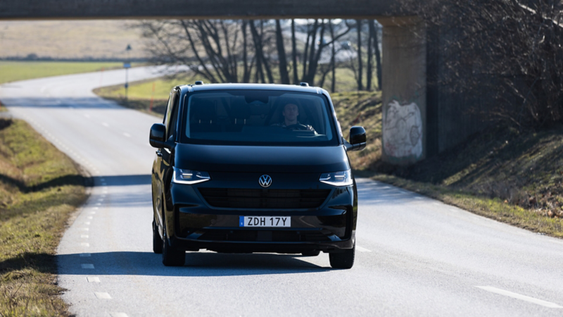Svart VW Transporter kör på en landsväg i Skåne