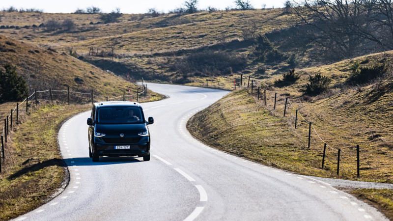 Svart VW Transporter kör på en landsväg i Skåne