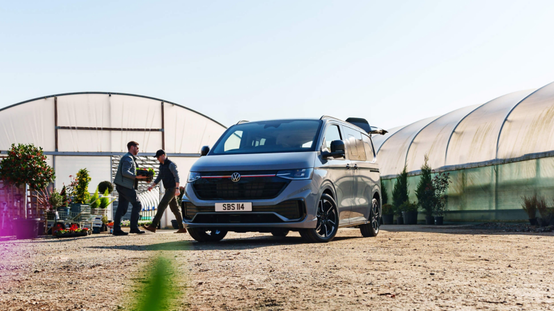 Volkswagen Transporter Sportline van parked on gravel outside greenhouse buildings