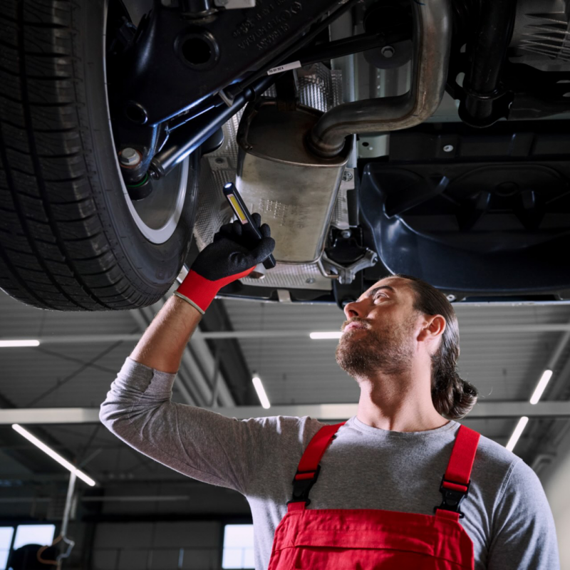 Un technicien Volkswagen Véhicules Utilitaires est en train de vérifier les amortisseurs d'un utilitaire