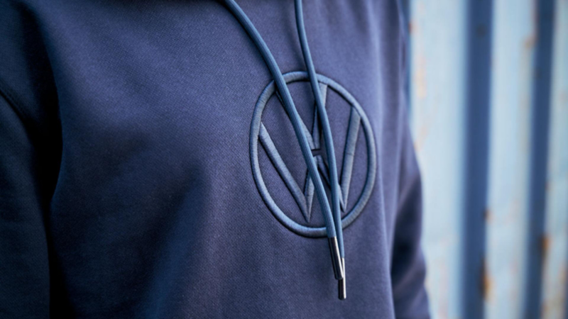 Detalle de sudadera oscura Volkswagen Essentials con logo en el pecho.
