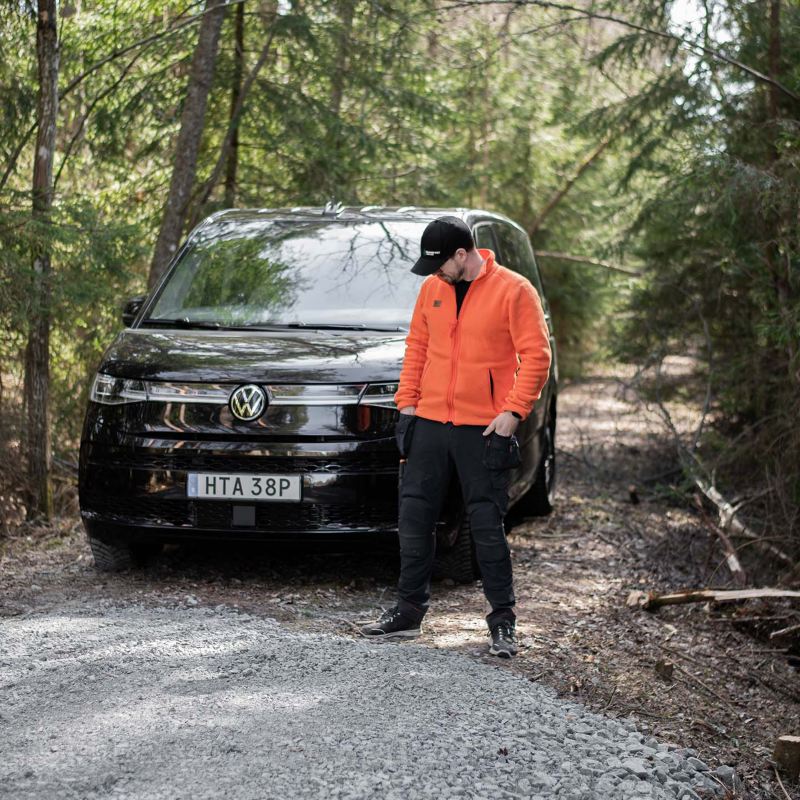 Victor Grankvist framför sin VW Multivan eHybrid på en grusväg i skogen