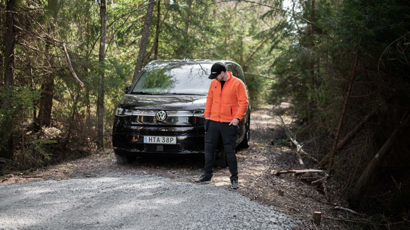 Victor Grankvist framför sin VW Multivan eHybrid på en grusväg i skogen