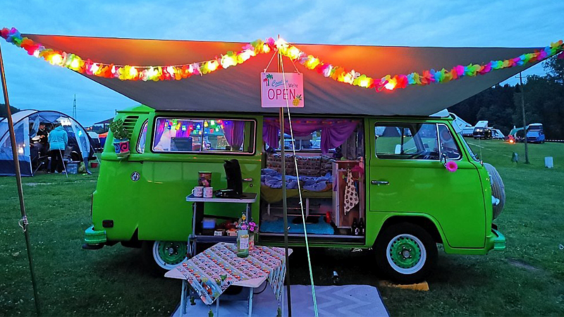 Susannes grüner VW Bulli aufgebaut auf einem Campingplatz.