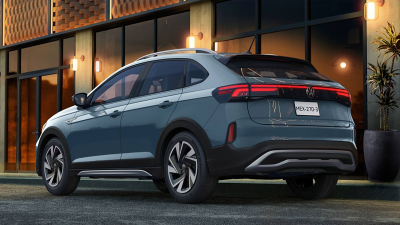 Vista trasera de Volkswagen Nivus 2026 en color azul grisáceo con luces LED y diseño aerodinámico frente a edificio moderno.