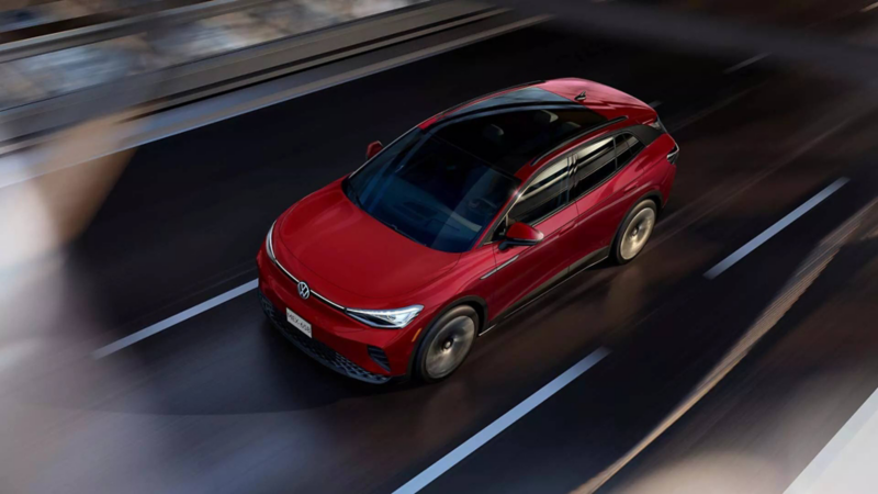 Volkswagen ID.4. Vista cenital de SUV eléctrico de color rojo en movimiento sobre una autopista.