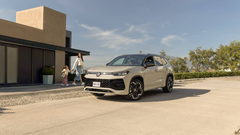 Mamá e hija caminan detrás de camioneta Tiguan 2026 blanca.