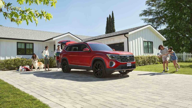 SUV de lujo Teramont 2024 en color rojo, a las afueras de una casa de color blanco. 
