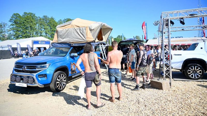 Festivalbesökare står vid Volkswagen Transportbilars monter på Sweden Rock 2023