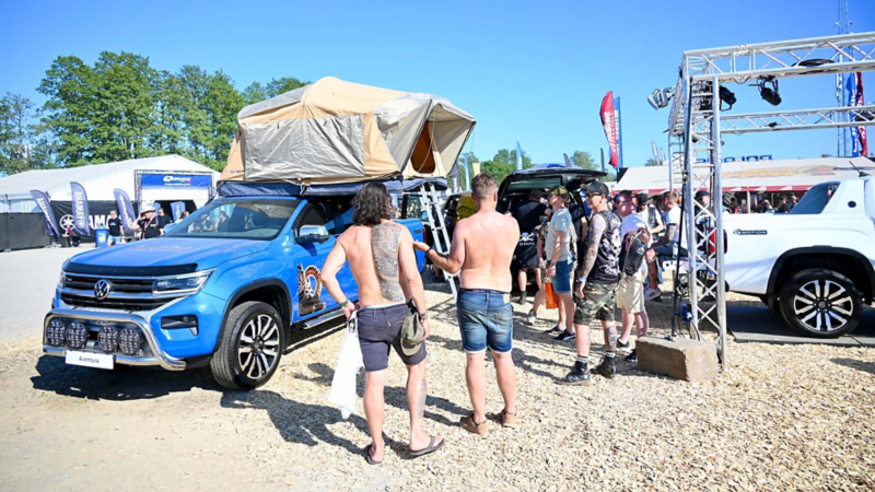 Festivalbesökare står vid Volkswagen Transportbilars monter på Sweden Rock 2023