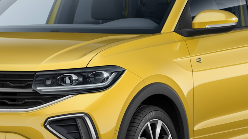 Close-up of a bright yellow Volkswagen T-Cross, showing the front-right corner. Features include a sleek headlight, modern grille, and curved paneling, conveying a sporty vibe.