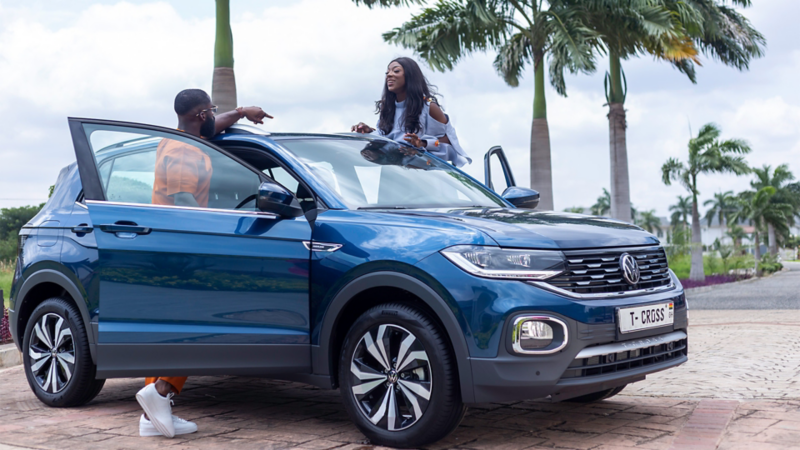 a man and woman on the outside of a blue Volkswagen T-Cross