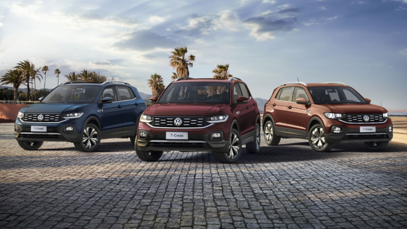Une VW T-Cross dans une rue en ville en partie ombragée. Un homme se promène en avant-plan.