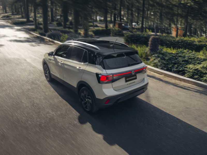 Nuevo Volkswagen T-Cross estacionado en un garaje, con una familia sonriente a su alrededor, destacando su diseño moderno y familiar.