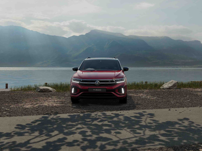 A front view of a red VW T-Roc Black Edition against a lake background