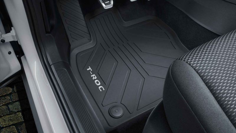 Przód białego VW T-Roc R-Line, włączone światła dzienne LED i opcjonalna iluminacja osłony chłodnicy.