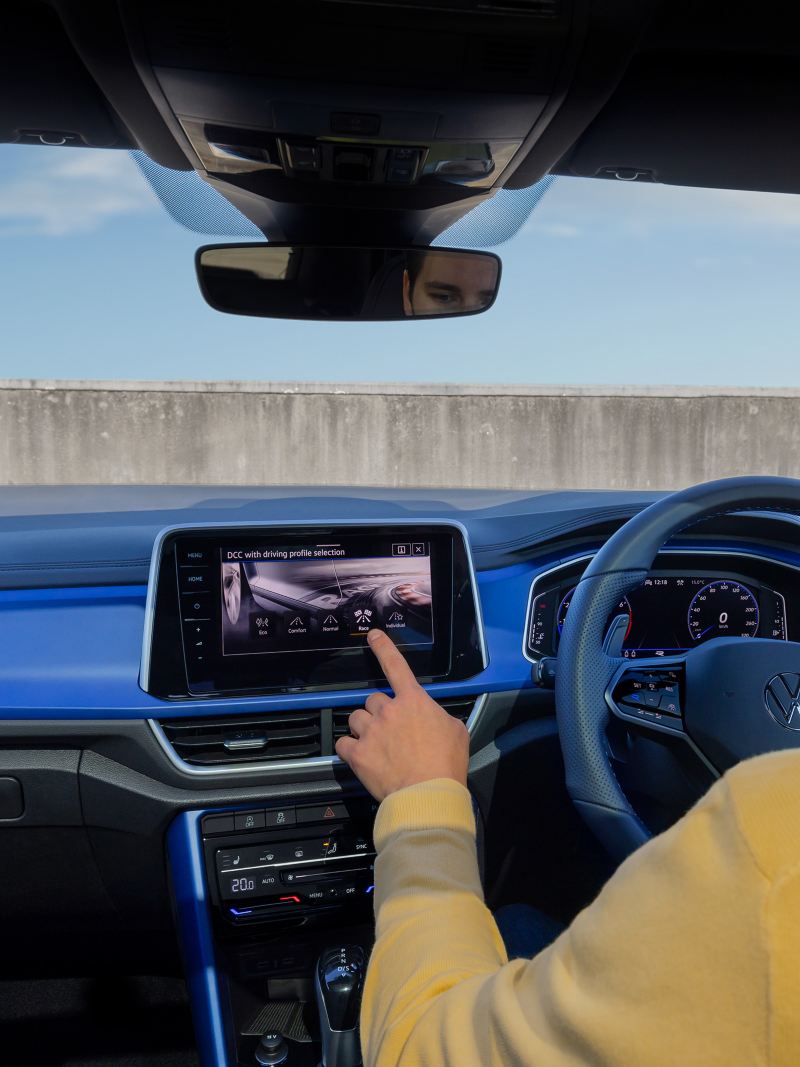 Man in the driving seat touching the infotainment system inside the Volkswagen T-Roc R.