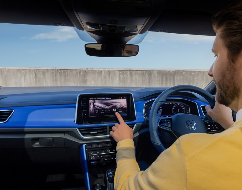 Man in the driving seat touching the infotainment system inside the Volkswagen T-Roc R.