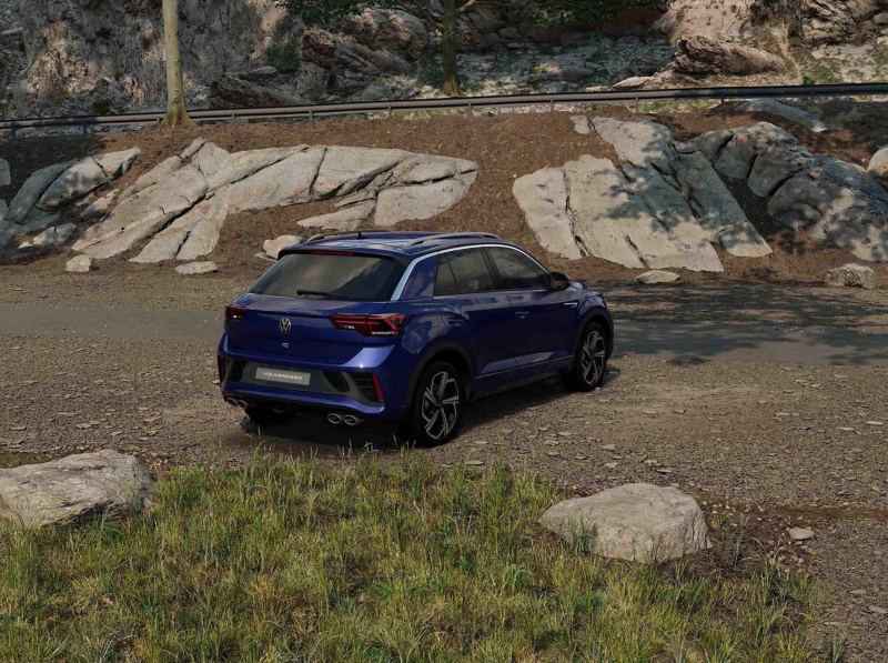 A back view of a blue VW T-Roc R against a rocky background