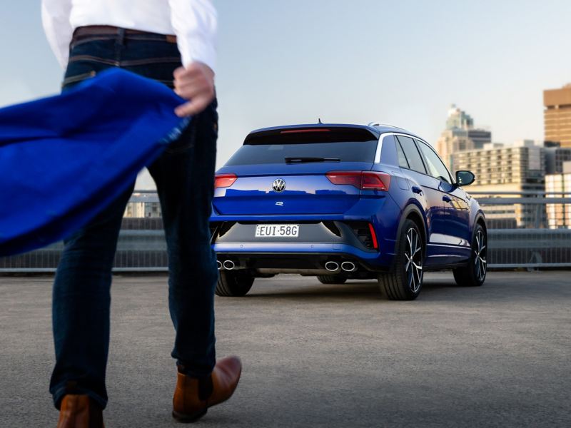 Rear side of the Volkswagen T-Roc R parked on the roof with man walking towards it.