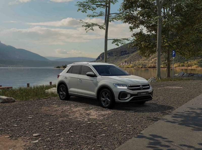 A white VW T-Roc R-Line against a lake background