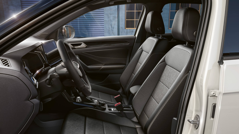 An interior shot of a steering wheel and front seats