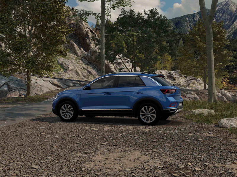 A side view of a blue VW T-Roc Style against a forest background
