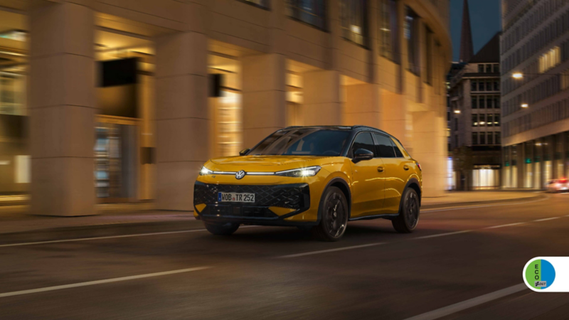 Un Volkswagen T-Roc amarillo circulando en la ciudad de noche