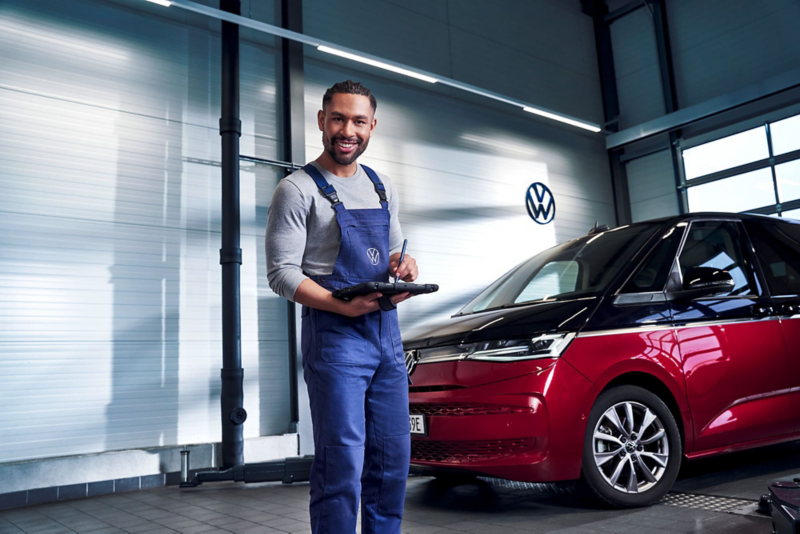 Pracownik serwisu na tle Volkswagena Multivana.