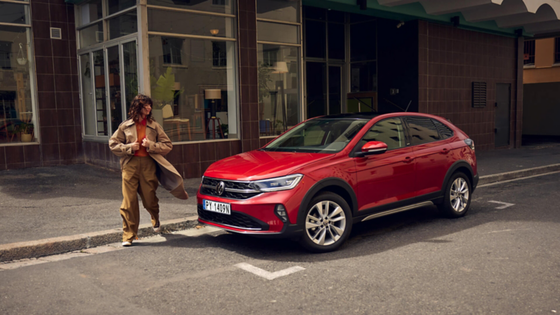 Kobieta wsiadająca do niebieskiego VW T-Cross