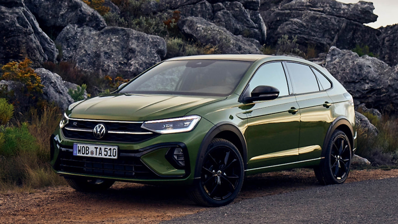 A Volkswagen Taigo parked against a mountainous background. 