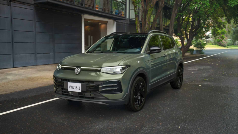 Volkswagen Taigun verde estacionado en una calle arbolada, visto en ángulo frontal derecho.